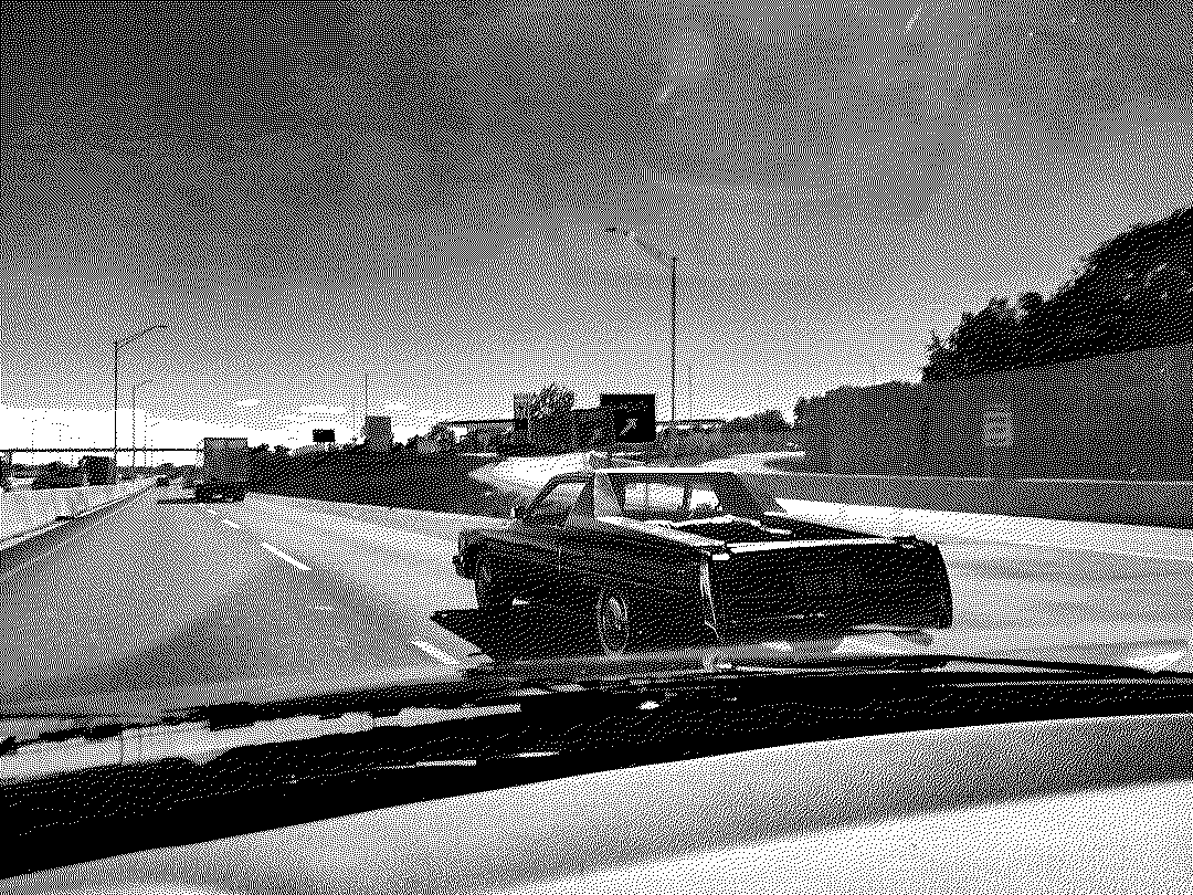 An old Cadillac pickup ahead on the interstate, seen through the windshield