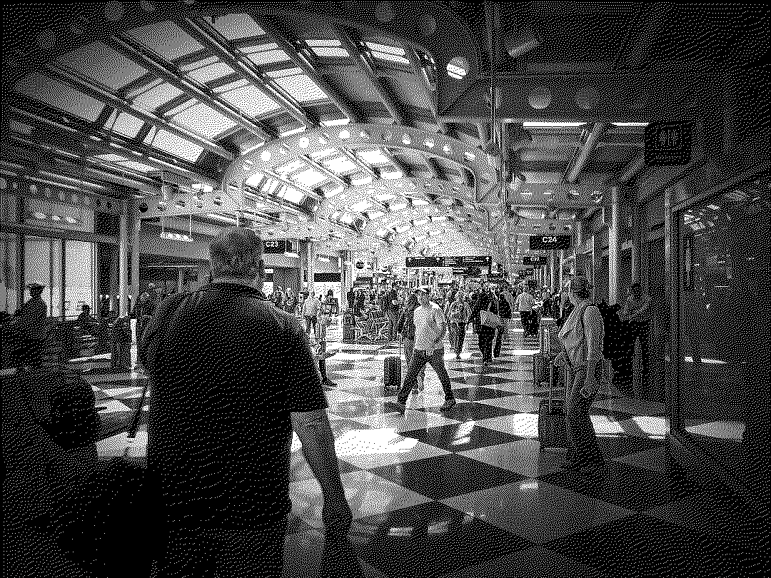 Travelers in an airport concourse under an arched glass roof